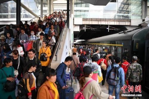 资料图:2018年3月12日,旅客在昆明火车站进站乘车。中新社记者